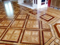 a wooden floor with geometric designs on the top and bottom, in an empty room