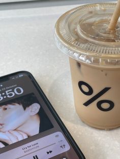 a cell phone sitting next to a cup of coffee and a drink on a table