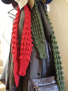 a handbag hanging on a coat rack with scarfs and hats attached to it