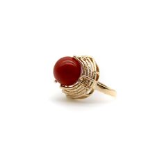 This is part of Chairish’s Fine Jewelry assortment.  At Kirsten’s Corner we love vintage coral, and this ring centers around a 12mm round sphere of well-saturated deep red Sardinian coral. The ball is centered in a tentacle-like circular mount that flows from its base and grasps the coral ball in a beautiful sci-fi fashion.  The 14k gold tentacles have a textured matte surface, ending in tiny golden balls that come together on either side of the sphere like finger tips on a hand. Circa the 1970’ 14k Gold Dome Ring With Cabochon, Elegant Red Dome Ring For Formal Occasions, Elegant 14k Gold Cabochon Dome Ring, 14k Gold Cabochon Dome Ring Elegant Style, Fine Jewelry Dome Ring With Cabochon, Formal Red Dome Ring, Sphere Ring, Orange Cocktails, Sci Fi Fashion