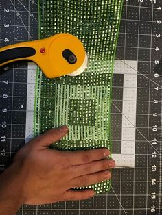 someone cutting fabric with a pair of scissors on top of it and measuring the length