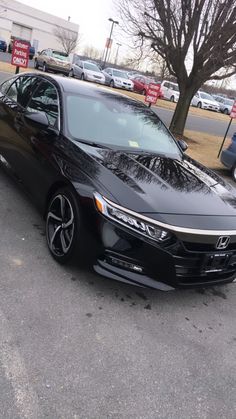 a black car is parked in the parking lot