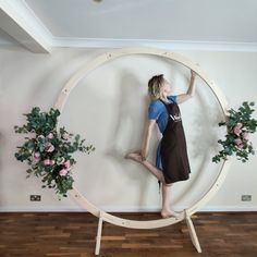 a woman standing in front of a wooden circle