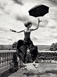 a woman with an umbrella jumping in the air