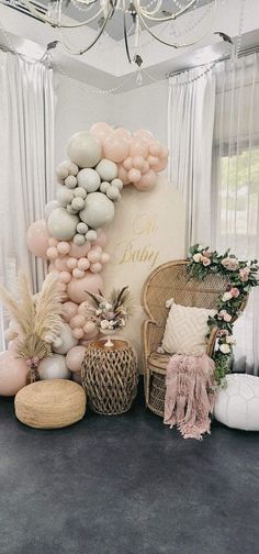 a room with balloons and other decorations on the wall, including a wicker chair