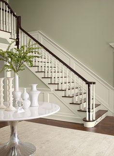 there is a vase with flowers on the table in front of the stair railings