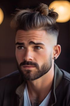 For a cool mix of casual and trendy, go for the low taper fade combined with a messy top knot hairstyle. This particular haircut with a messy top knot has shorter sides that gradually fade. Click here to check out more handsome low taper fade haircuts for men. Mid Fade Long On Top, Top Knot Hairstyle, Messy Top Knot, Volume Haircut, Knot Hairstyle, Haircut Designs For Men