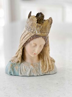 a figurine with a crown on top of it's head sitting on a table