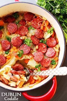 a pot filled with sausage and vegetables on top of a table