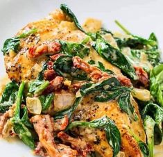 a white plate topped with chicken and spinach