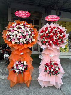 three different types of umbrellas with flowers on them in front of a storefront