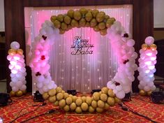 an arch made out of balloons and other decorations on a stage at a birthday party