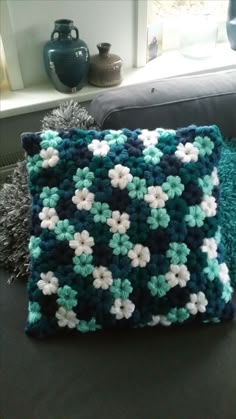 a crocheted pillow sitting on top of a couch