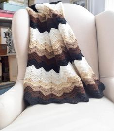 a crocheted blanket sitting on top of a white chair