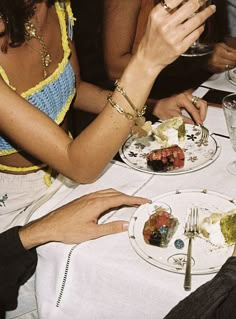 two people sitting at a table with plates of food