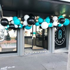 the entrance to a building decorated with balloons and black, white, and blue colors