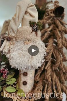 a stuffed animal is sitting in front of some christmas tree branches and pine cones on the table