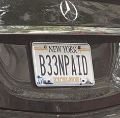 a mercedes license plate on the back of a black car with new york b383npadd