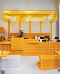 the interior of a restaurant with yellow tiled walls