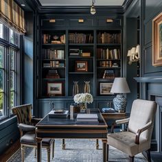 a room with bookshelves, chairs and a desk in front of a window