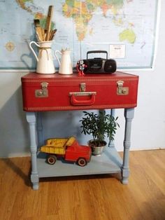 a red suitcase sitting on top of a wooden table