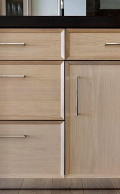 a kitchen with wooden cabinets and black counter tops