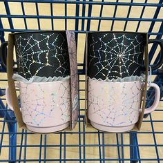 two coffee mugs sitting on top of a shelf