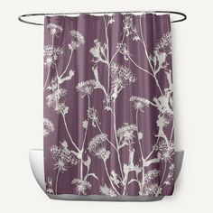 a purple shower curtain with white flowers on it