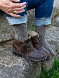 This top-down, richly-textured sock in two sizes S(L) is a gorgeous accessory for men and women alike. Worked in a warm, wooly yarn it is a hiking/rowing/snowshoeing essential; in sleek, smooth yarn it is a stylish accent to casual suits or slacks. With cabled details on all sides and cushy moss stitch panels, it is fun to work and a small project to be proud of—plus, a gift that says you think the most of a special someone. Shown here is size S in Border Leicester Fingering, color Rainbow GrayS