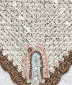 a crocheted doily with two tassels on it