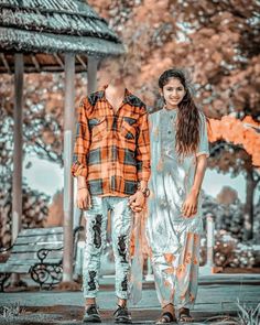 two people standing next to each other in front of a gazebo