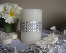 a white candle and some flowers on a table