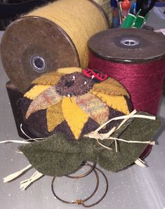 two spools of thread are sitting on top of some fabric and other crafting supplies