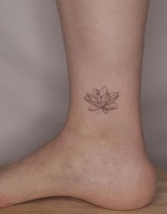 a woman's foot with a small lotus tattoo on the side of her ankle