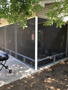 a bbq grill sitting on top of a patio next to a brick building