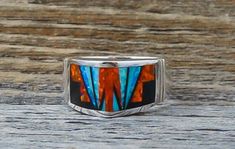 This band ring is handcrafted with Sterling Silver and beautifully inlaid with bright , dazzling, Fire Lab Opal and Onyx. As is seen in this work of art, the artist's talent is evident! It is a favorite due to the expertly clean cut geometric work, followed by the angular shape of the ring. This is that signature accessory that will compliment your wardrobe. We are proud to offer the David Rosales Collection of fine Native American Indian Jewelry. He has built a reputation for the finest inlaid Multicolor Inlay Rings For Anniversary, Anniversary Multicolor Inlay Rings, Unique Multicolor Rings With Polished Finish, Artisan Rings With Inlay For Anniversary, Southwestern Style Rings With Inlay As Gift, Southwestern Style Rings With Inlay For Gift, Multicolor Inlaid Ring Jewelry, Multicolor Inlay Ring Jewelry, Artisan Multicolor Rings With Inlay