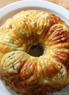 a bundt cake on a white plate sitting on a wooden table