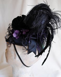 "This unique gothic-victorian masquerade headpiece was inspired by the luxurious Venice Carnival head-dresses. Created in a combination of midnight blue, black and purple. The teardrop base is covered with wonderful two-toned blue and black taffeta. I've used a gorgeous metal \"lace\" mask with rhinestones as the focal point. A glorious bouquet of flowers and feathers create a textured and one of a kind piece. A fluffy black ostrich, along with long iridescent rooster feathers and accents of pur Masquerade Headpiece, Victorian Headpiece, Victorian Masquerade, Flowers And Feathers, Head Dresses, Mardi Gras Costumes, Venice Carnival, Rooster Feathers, Lace Mask