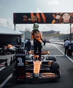 a man standing on top of a race car