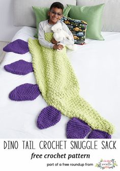 a child is sitting on a bed with a crocheted mermaid blanket