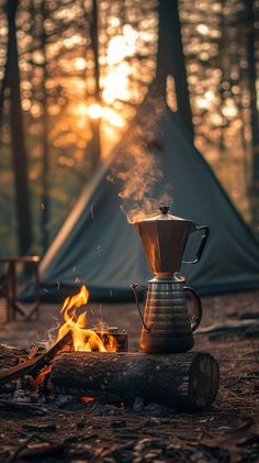 a coffee pot sitting on top of a fire next to a tent