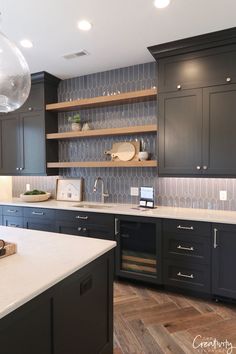 a kitchen with black cabinets and white counter tops