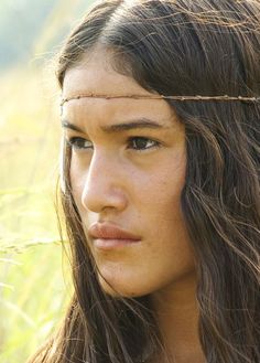 a close up of a person with long hair and wearing a head band on her head