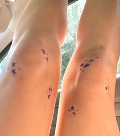 the legs of a woman with purple stars on her left leg and right leg behind her