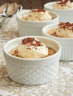 two white bowls filled with dessert on top of a table