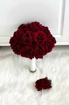 a bouquet of red roses sitting on top of a white rug