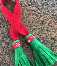 a red and green ribbon with snowflakes on it is laying on the ground