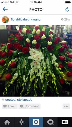 a bunch of flowers sitting on top of a wooden table in front of a phone