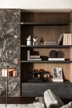 a living room filled with furniture and bookshelves next to a wall mounted book shelf