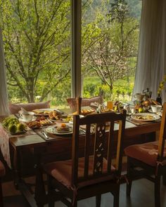 a dining room table set with plates and fruit on it